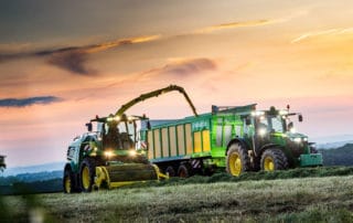 Zelene poljoprivredne mašine obradjuju njivu